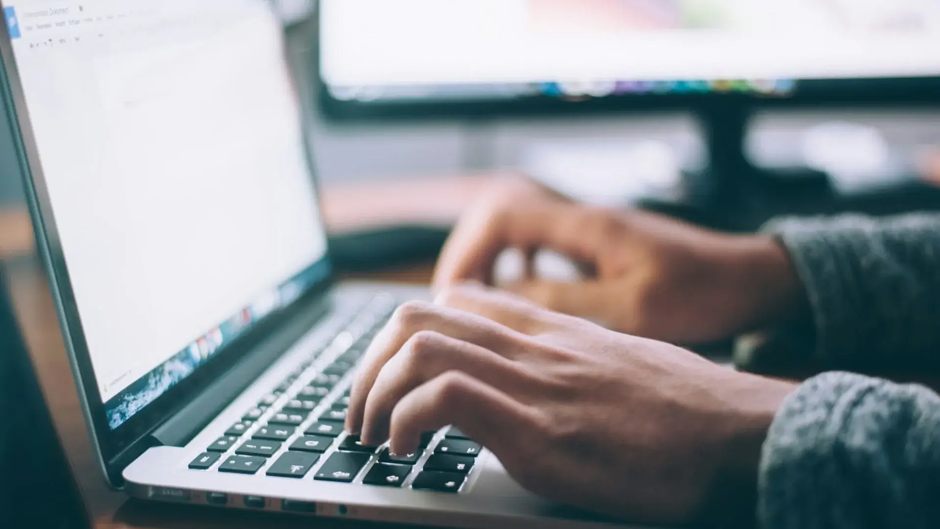 Author typing at laptop to manage direct book sales
